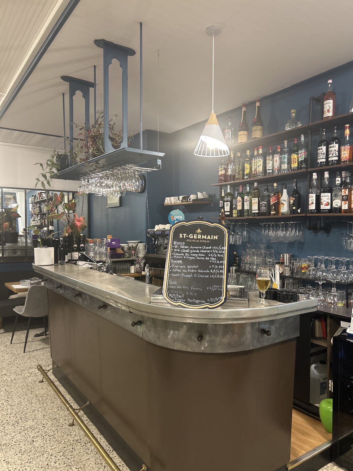 Die Zinktheke, die Weintafel und Flaschenregale an der blauen Wand